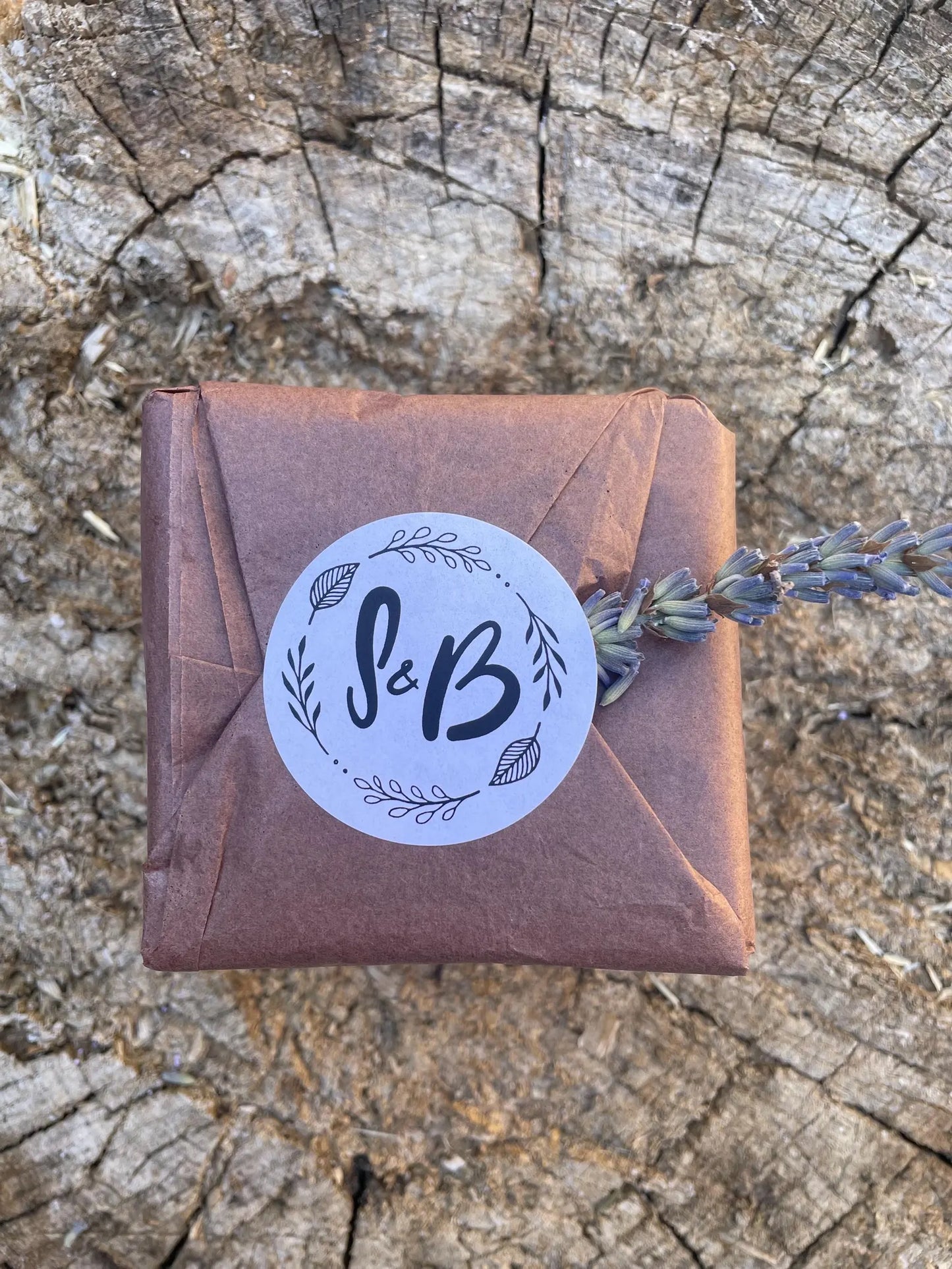 Beautifully gift-wrapped Soapy & Bubbly lavender soap with a branded sticker and a fresh sprig of dried lavender, ready to be gifted.