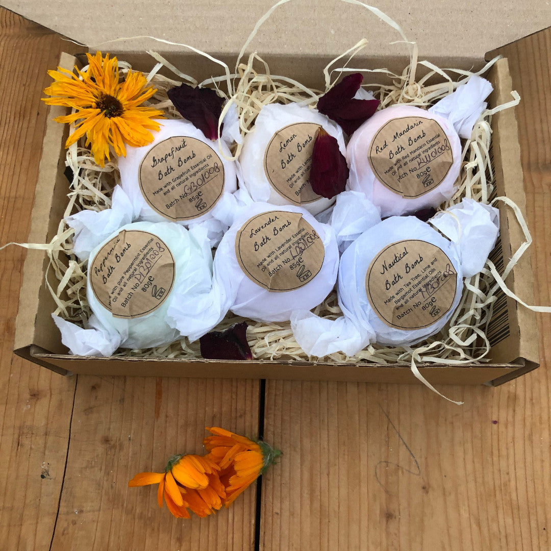 Set of bath bombs wrapped and labeled by Soapy and Bubbly on a wooden table