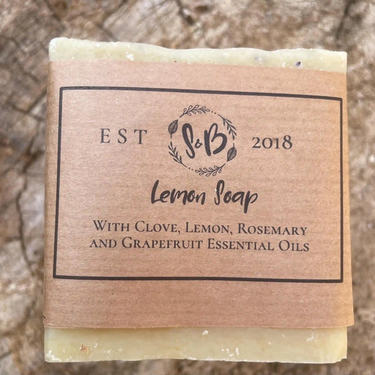 Close-up of a bar of Soapy & Bubbly's handmade Lemon Soap with its kraft paper packaging.