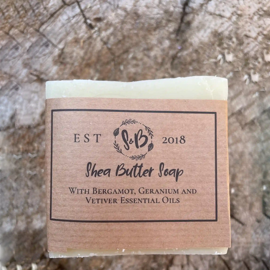 A single bar of natural Shea Butter Soap with its simple, elegant Soapy & Bubbly paper wrap.