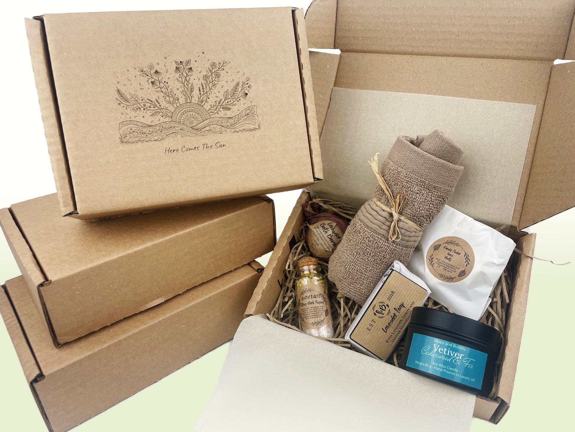 Here comes the sun motivational gift box with sunrise illustration near the open box with self-care products